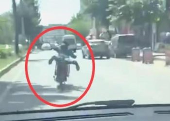 Motosikleti akan trafikte, üzerine yüzüstü yatarak kullandı
