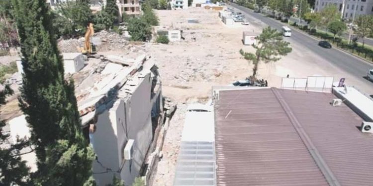 Ağır hasarlı binanın duvarı işyerinin üzerine yıkıldı